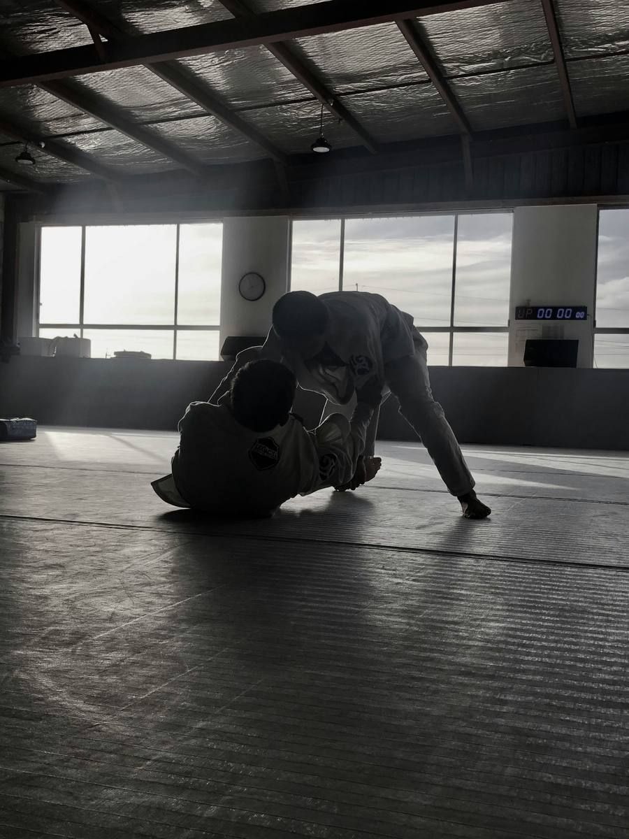 Two people training BJJ on the mat
