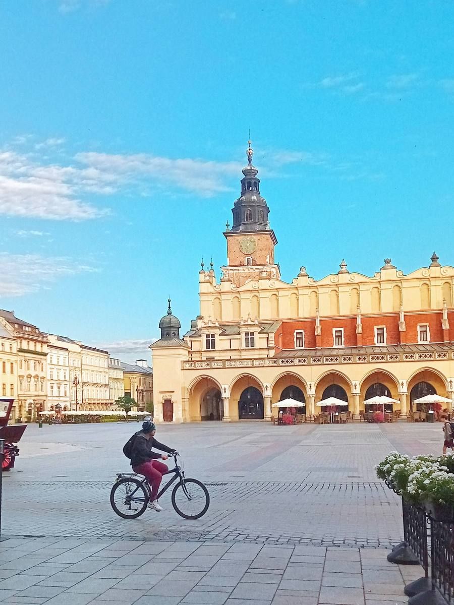 Cyclist crossing the Main Market Square in front of the Cloth Hall
