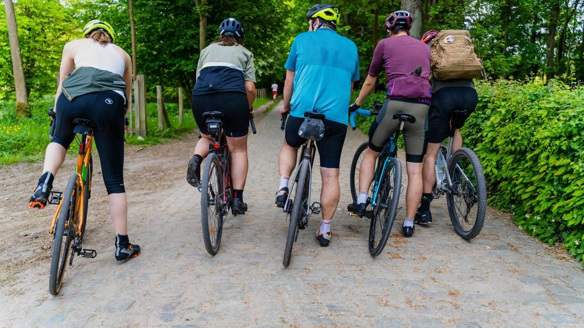 A group of cyclists on a cobbled forest road